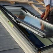 Worker installing a sky-light on the roof of a building